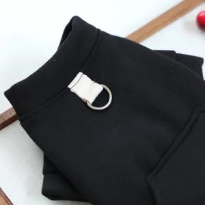 Black pet hoodie detail showing the metal D-ring leash attachment and cozy pocket for small dogs.