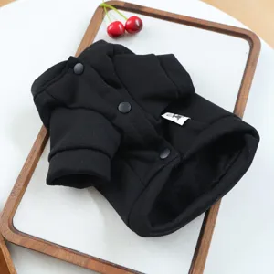 Close-up detail of black pet dog sweater, warm fleece button coat apparel for small puppies.