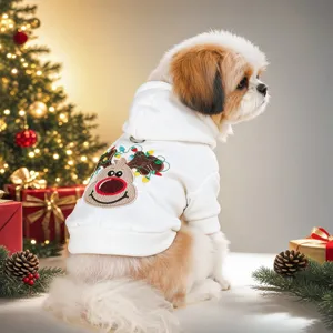 Close-up view of a cute puppy wearing a festive white Christmas hoodie with reindeer embroidery.