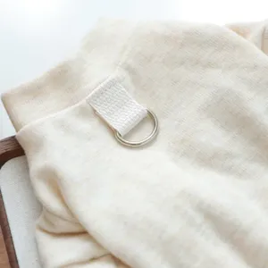Close-up detail of soft beige pet clothes with a metal D-ring for daily wear comfort.