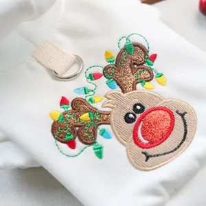 Close-up detail of cute Christmas reindeer embroidery on white pet hoodie with D-ring.