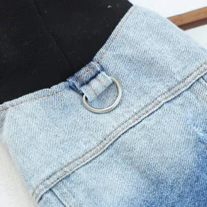 Close-up detail of stylish pet denim jacket featuring black hood, metal D-ring, and stitching.