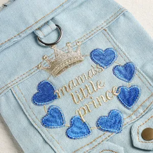Close-up view of pet denim jacket pocket featuring crown and blue heart embroidery details.