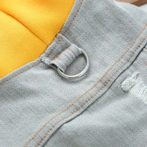 Dog denim jacket fine detail view showing blue fabric, yellow insert and steel D-ring.