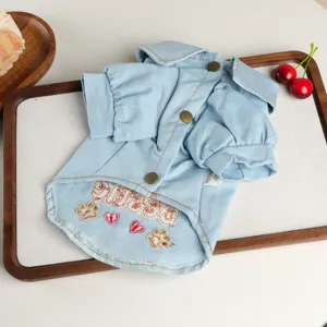 Detailed view of blue denim pet shirt with lapel, buttons, and cute paw embroidery designs.