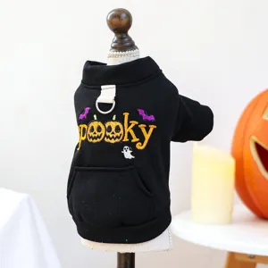 Close-up detail of a black pet hoodie with spooky pumpkin embroidery and a traction ring.