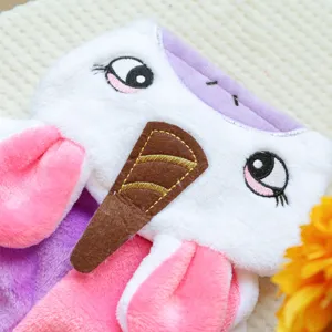 Primo piano dettagliato della felpa in peluche per animali con occhi ricamati e corno.