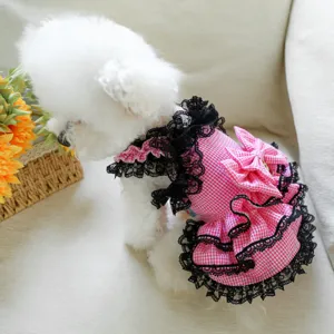 Cute pink checkered pet dress for small dogs with black lace trim and bow detail close up.