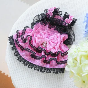 Detail close-up of the pink checkered pet dress showcasing exquisite black lace and cute bow details.