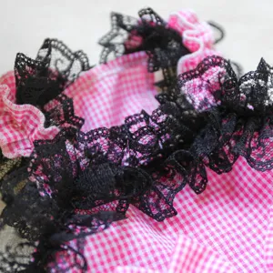 Detailed view of the pink gingham pet dress featuring elegant black lace trim design.