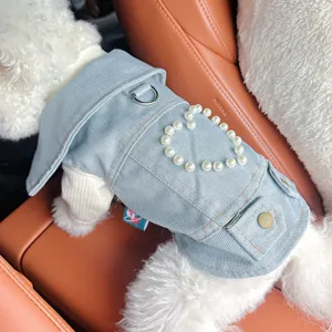 Close-up detail of pet denim jacket with pearl heart pattern and metal D-ring for small dogs.