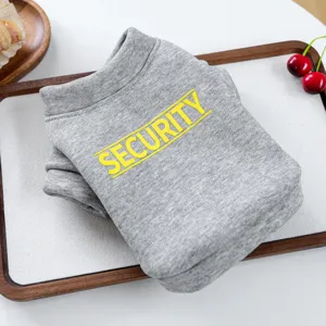 Detalle en primer plano de la sudadera gris para mascotas sobre bandeja de madera.