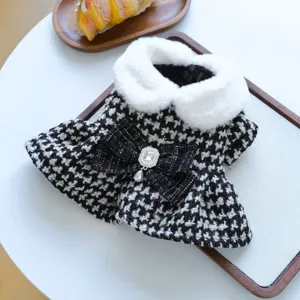 Detail robe de animal motif pied-de-poule, col en fausse fourrure blanche et noeud en cristal.