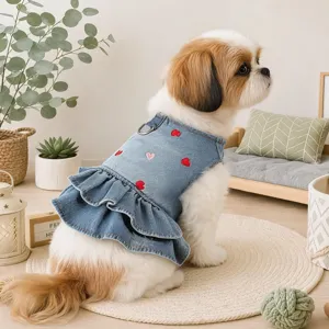 Detail view of cute dog denim dress featuring sweet heart embroidery and ruffle hem design.