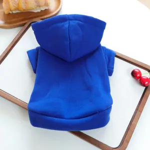 Blue pet hoodie detail shot, solid color hooded dog clothes, soft puppy apparel for autumn.