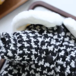Vue détaillée de vêtements d'hiver pour chien avec un tissu en pied-de-poule noir et blanc.