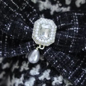 Détail de la robe pour animaux en tweed noir et blanc avec broche perle et strass et pendentif.