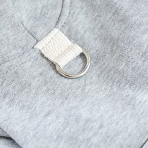 Gros plan sur le détail d'un sweat pour animal gris avec anneau en métal et boucle.