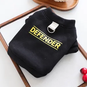 Detalle en primer plano de sudadera negra para mascota con estampado amarillo y anilla D cachorro.