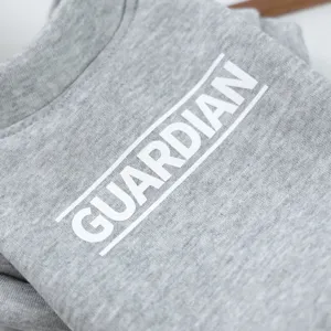 Close-up detail of grey pet dog sweatshirt with white letter print, soft fabric texture.