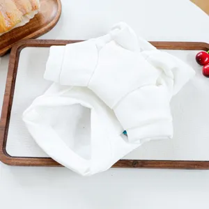 Detailed shot of a plain white pet hoodie, folded neatly on a wooden tray for autumn winter.