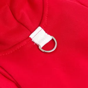 Red pet hoodie clothing detail view showing white fabric loop and silver metal D-ring attachment.