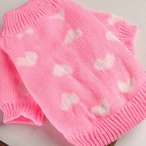 Detailed view of a cute pink pet sweater featuring a sweet white heart knit pattern for small dogs.