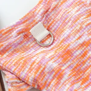 Detail shot of colorful knitted pet apparel fabric, featuring a metal D-ring traction loop.