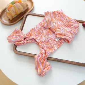 Detailed view of the pink and orange knitted puppy pet clothing, showcasing the textured fabric.