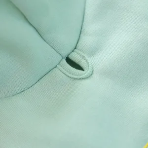 Dettaglio felpa per animali verde menta con foro per guinzaglio e tessuto morbido.