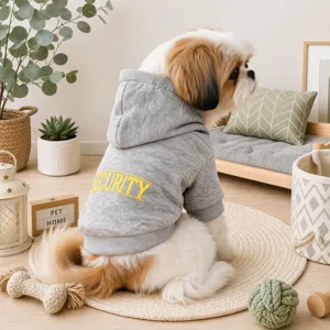 Vista dettagliata della felpa grigia per cani con stampa security e sfondo domestico accogliente.