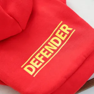Detailed close-up view of a red pet dog hoodie featuring bold yellow letter print and cozy hood.