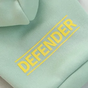 Close-up detail shot of cute pet hoodie fabric, showing mint green texture and print.