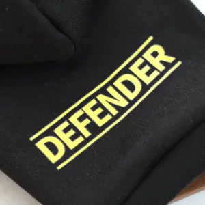 Detailed view of black pet hoodie with yellow defender text print, showing fabric and print quality.