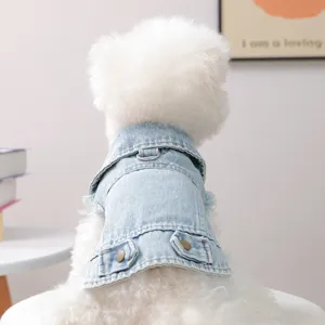 Detailed view of cute pet dog wearing retro light blue denim jacket with collar and metal buttons.