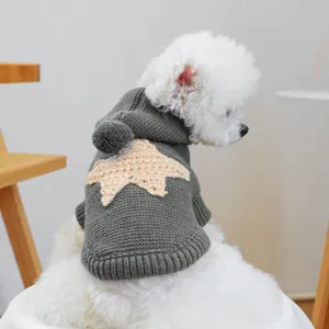Detail shot of cute grey knitted pet sweater with star motif and hood for small dogs.