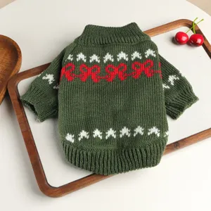 Close-up detail view of a cute green pet knit sweater featuring festive red and white winter patterns.