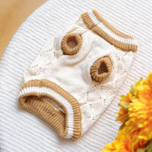 Close up detail of knitted pet sweater in beige and brown with hollow out pattern and rib trim.