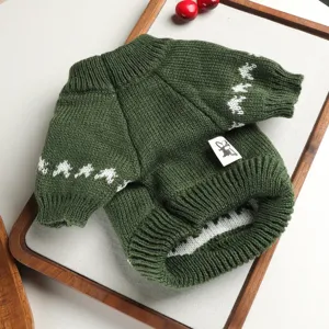 Close-up detail of the green knitted pet sweater with white pattern and cute tag, soft fabric.