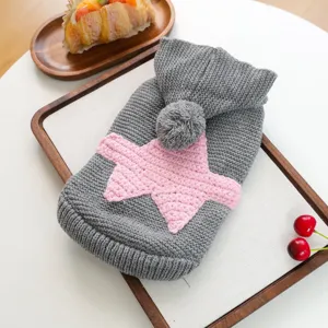 Close-up detail of the cozy gray knitted pet sweater featuring a pink star and cute pom-pom.