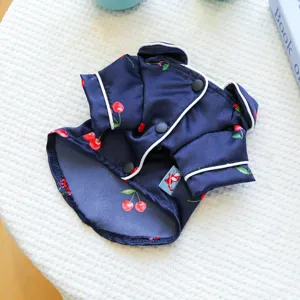 Cute pet cherry pajamas detail view, dark blue fabric with red cherries and white trim.