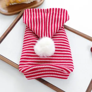 Close-up of red and white striped pet knitted hoodie with fluffy pom-pom detail