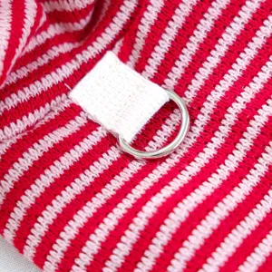 Close-up detail of red and white striped pet sweater fabric with metal d-ring and loop.