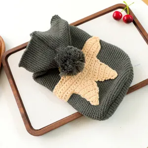 Cozy grey knit pet sweater for small dogs, featuring a cute beige star patch and fluffy pom-pom hat.