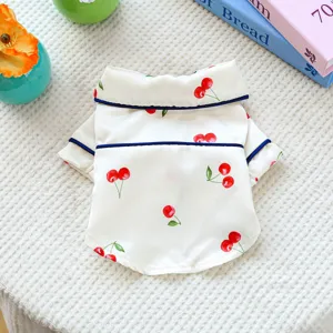 Detail view of pet pajama with cute cherry print, satin fabric and blue piping trim.