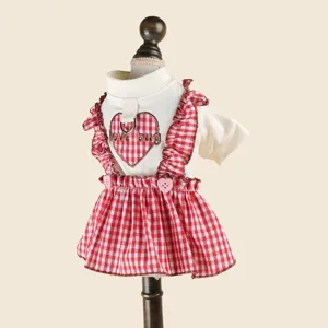 Detailed view of cute pet dog cat dress with red gingham pattern heart motif and leash ring.