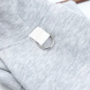 Close-up detail of grey pet hoodie fabric with durable metal D-ring and secure strap for small dogs.
