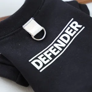 Close-up detail of black pet hoodie featuring metal D-ring and white letter print.