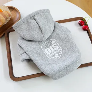 Detailed view of gray pet hoodie with hood and white printed logo on a neat wooden tray.