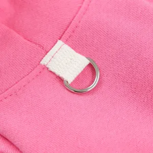 Detail shot of pet clothing with pink fabric, white canvas loop and metal D-ring.